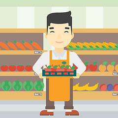 Image showing Supermarket worker with box full of apples.