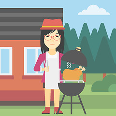 Image showing Woman cooking chicken on barbecue grill.