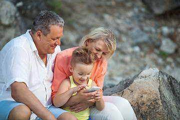 Image showing Happy boy with cell phone and grandparents outdoor