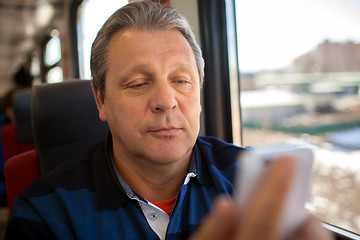 Image showing Man using mobile phone during train ride