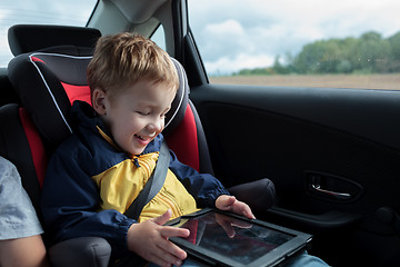 Image showing Happy boy playing with touchpad in the car