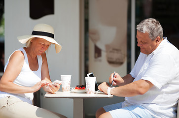 Image showing Couple sitting in cafe while using gadgets