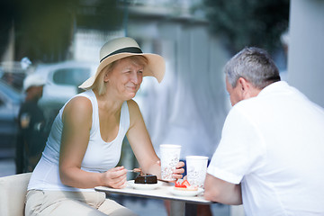 Image showing Smiling elderly woman eating in cafe with her husband