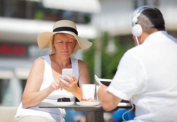 Image showing Adult couple at table using devices