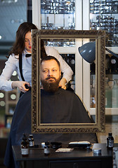 Image showing Man having his beard and hair trimmed at a barber