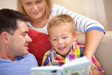 Image showing Young family reading a book together