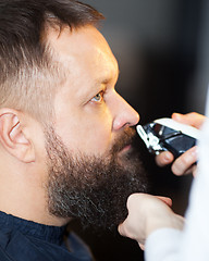 Image showing Man having his mustache trimmed at a barber