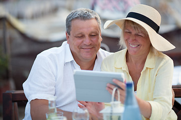 Image showing Smiling middle-aged couple using a tablet