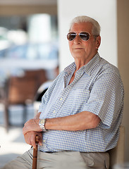 Image showing Senior man in sunglasses sitting waiting