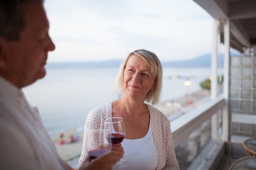 Image showing Senior woman drinking wine with husband on balcony