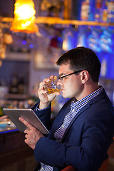 Image showing Businessman enjoying a drink at a club