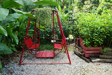 Image showing Red swing hanging in garden