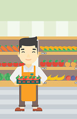 Image showing Supermarket worker with box full of apples.