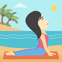 Image showing Woman practicing yoga upward dog pose on beach.