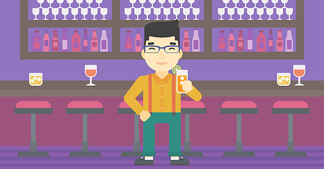 Image showing Man drinking orange cocktail at the bar.