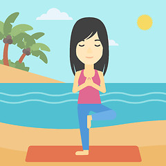 Image showing Woman practicing yoga tree pose on the beach.