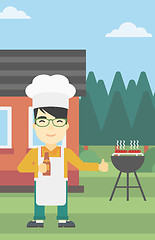 Image showing Man cooking meat on gas barbecue grill.