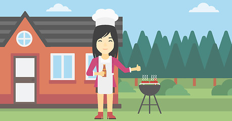 Image showing Woman cooking meat on gas barbecue grill.