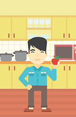 Image showing Young man with apple in the kitchen.