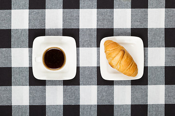 Image showing Coffee cup with saucer and croissant