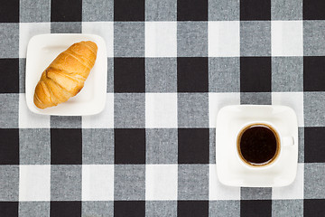 Image showing Coffee cup with saucer and croissant