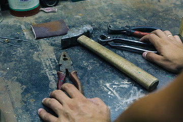 Image showing male hands near tools on iron table