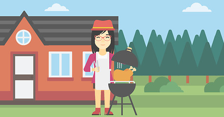 Image showing Woman cooking chicken on barbecue grill.