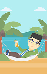 Image showing Man chilling in hammock with cocktail.