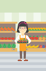 Image showing Supermarket worker with box full of apples.