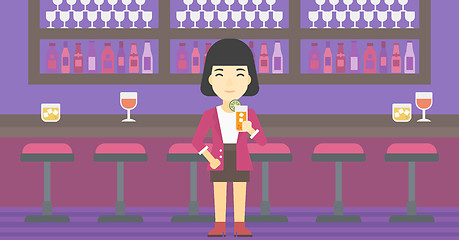 Image showing Woman drinking orange cocktail at the bar.