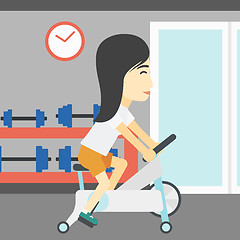 Image showing Woman riding stationary bicycle.