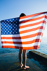 Image showing Back view of female with American flag against  sea