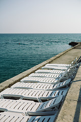 Image showing Deckchairs at asphalt coast