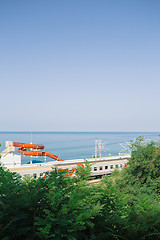 Image showing Train railing along coastline with aquatic slide against the sea