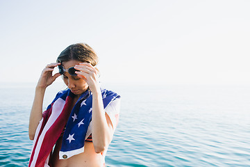 Image showing Wet-haired woman putting on swimming goggles