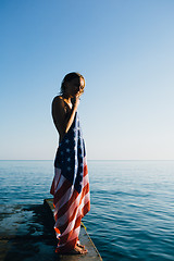 Image showing Short-haired woman with american flag on pier