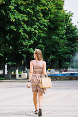 Image showing Young brunette woman walking in park against of fountain