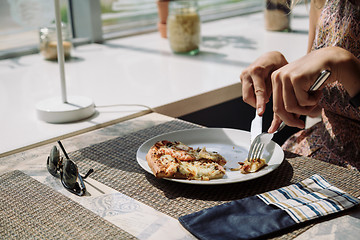 Image showing Unrecognizable woman eating pizza in cafe