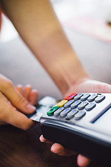 Image showing Female hand inserts the credit card into the terminal