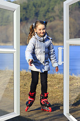 Image showing girl goes in roller skates seen from the window