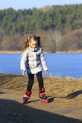 Image showing young girl goes in roller skates on the ground