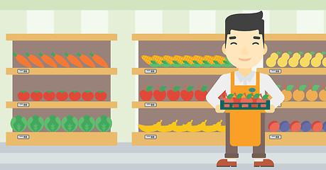 Image showing Supermarket worker with box full of apples.