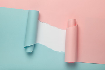 Image showing Torn blue and pink colored paper