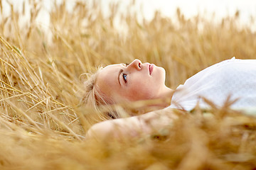 Image showing young woman lying on cereal field and dreaming