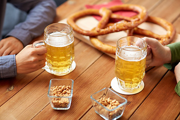 Image showing close up of hands with beer mugs at bar or pub