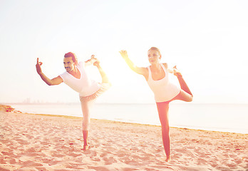 Image showing couple making yoga exercises outdoors