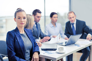 Image showing businesswoman in office with team on the back