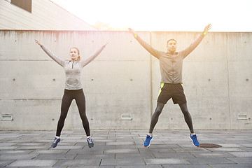 Image showing happy man and woman jumping outdoors