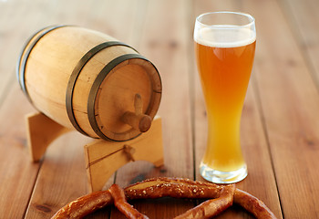 Image showing close up of beer glass, pretzel and wooden barrel