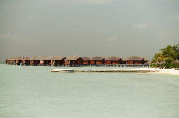 Image showing bungalow huts in sea water on exotic resort beach